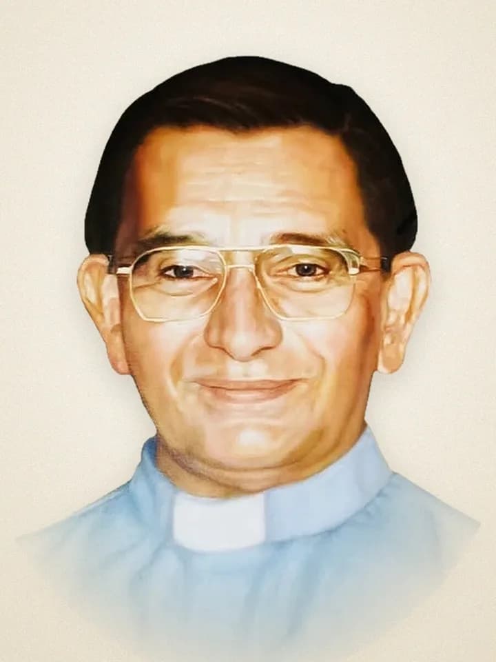 A portrait of Msgr. Frederick “Fred” Kriekenbeek, smiling, in glasses and a light blue clerical shirt.